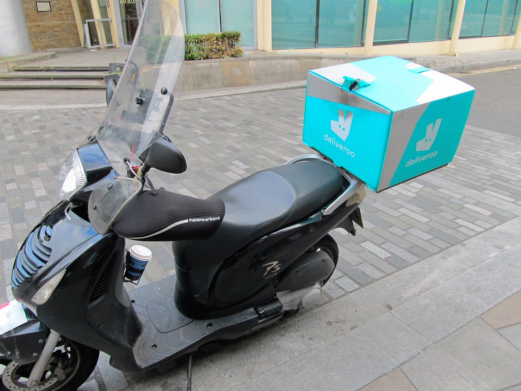 外送機車在路邊，象徵尖峰時段接單策略